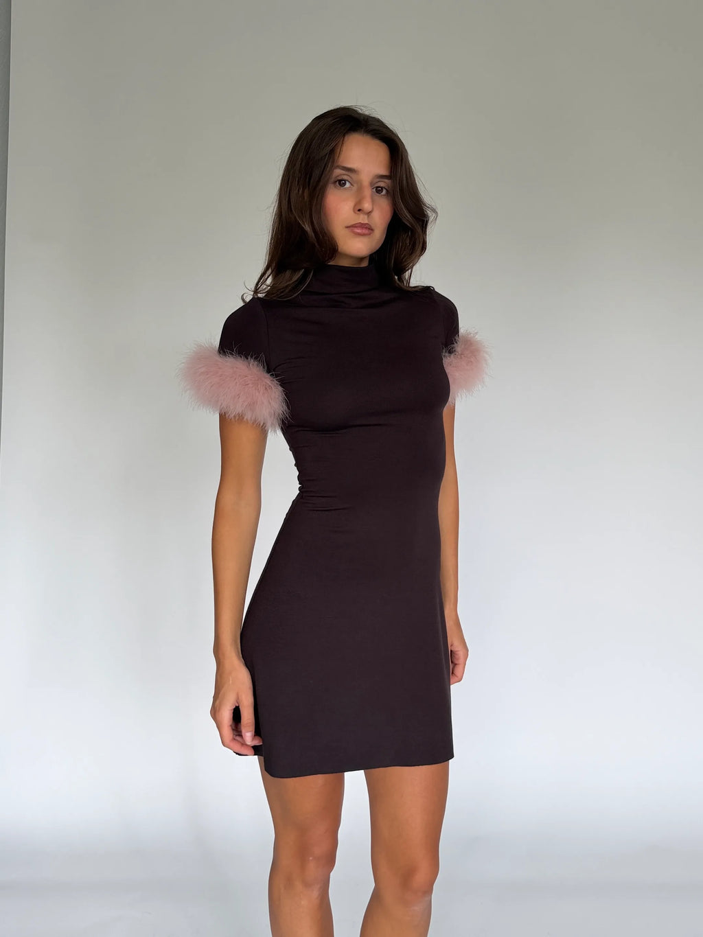 Close view of the NOA mini dress: high mock neck and pale pink marabou cuffs on short sleeves